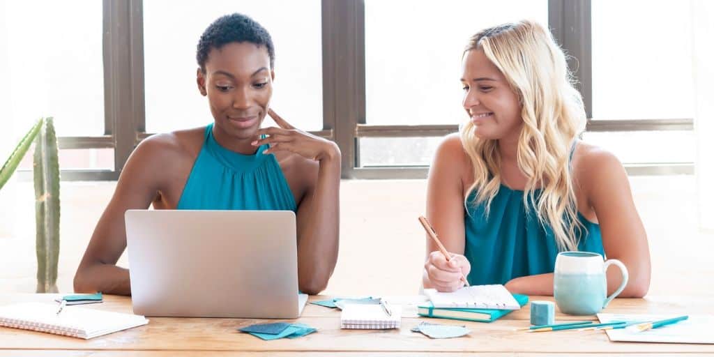 two women online shopping with computer, excited about tips to save money