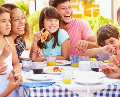 multi families on vacation, eating meals together