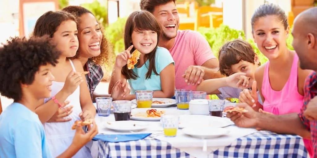 multi families on vacation, eating meals together