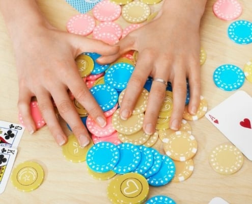 table flatlay with poker chips and cards, fun money saving games