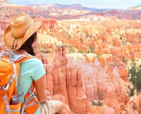 woman with backpack overlooking canyon as fun thing to save up for