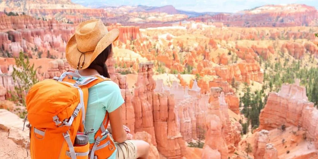 woman with backpack overlooking canyon as fun thing to save up for