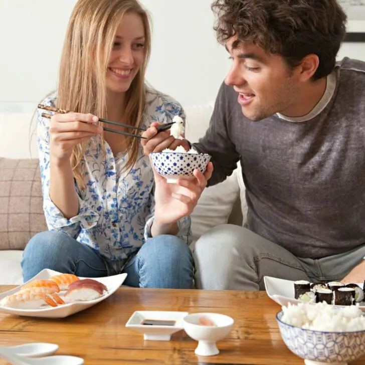guy and gal eating grocery store sushi at coffee table