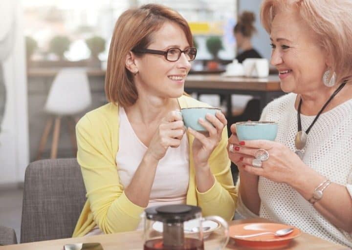 adult woman drinking tea with mom at restaurant for mother's day