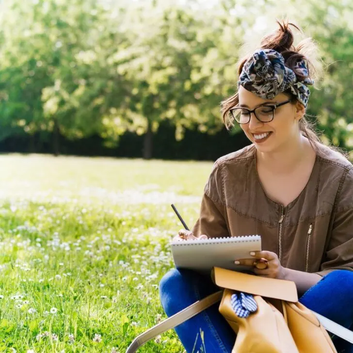 woman happily writing letter volunteering in home backyard