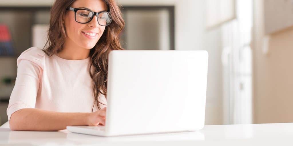 woman teacher with glasses working on esl teaching online job on laptop