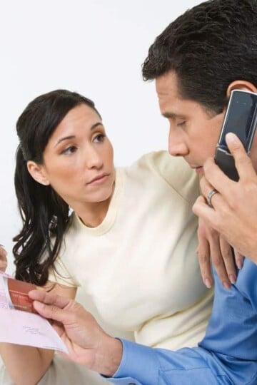 husband and wife with bill on phone for financial assistance