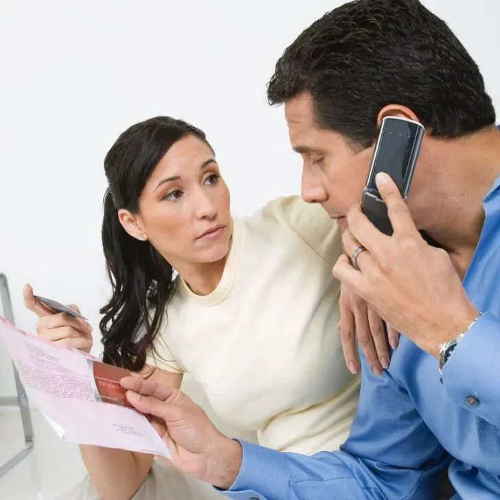 husband and wife with bill on phone for financial assistance