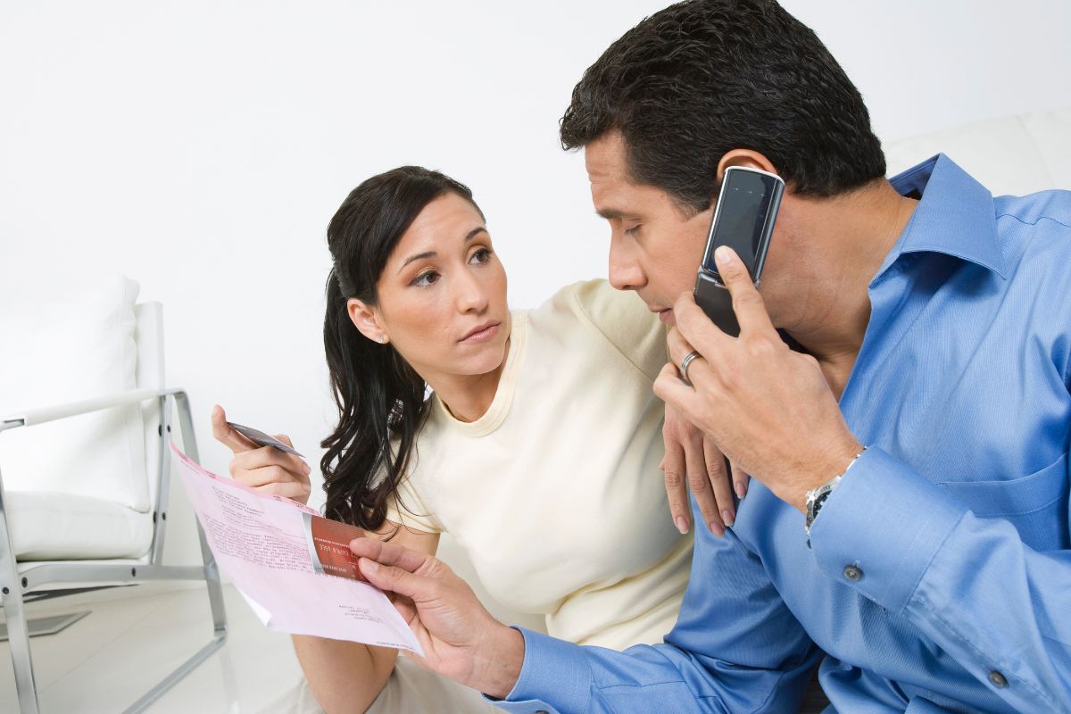 husband and wife with bill on phone for financial assistance