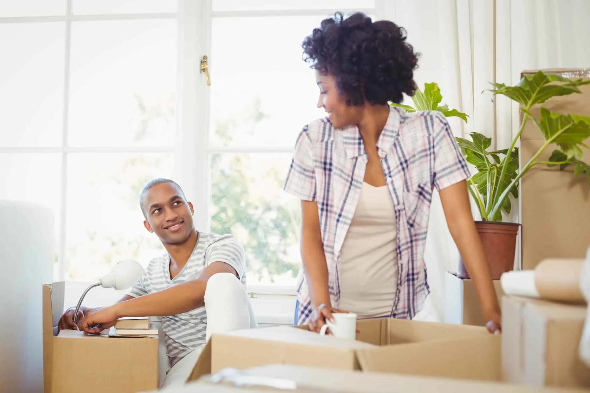 happy couple unboxing belongings in new apartment, wondering how well they negotiated their rent