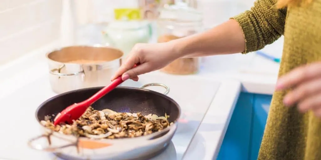 woman cooking a pantry meal in a skillet on the stovetop