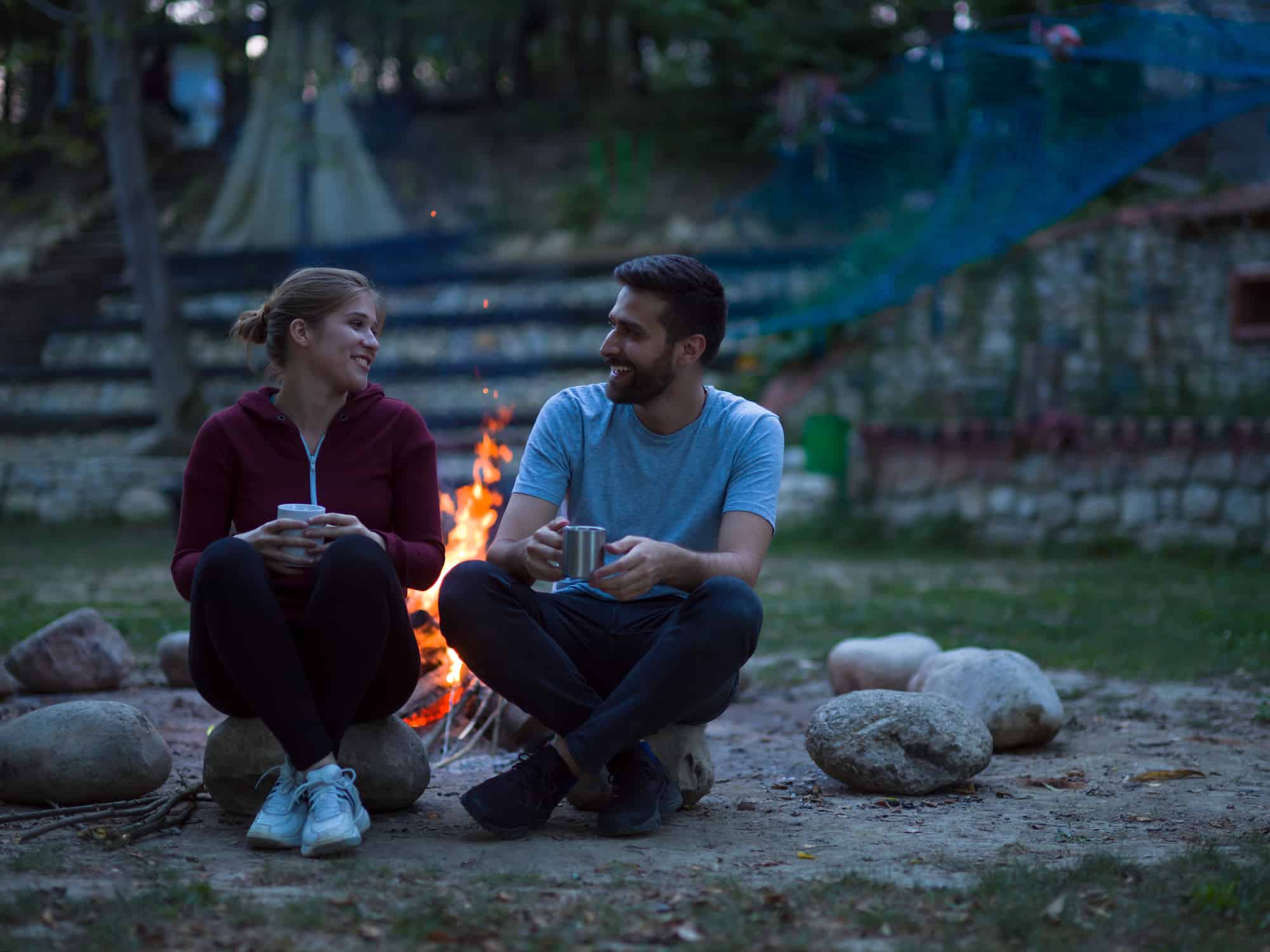 couple outdoor near fire pit on summer night