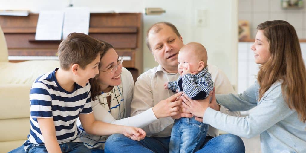 family with two young kids, playing on the floor, real story of living paycheck to paycheck