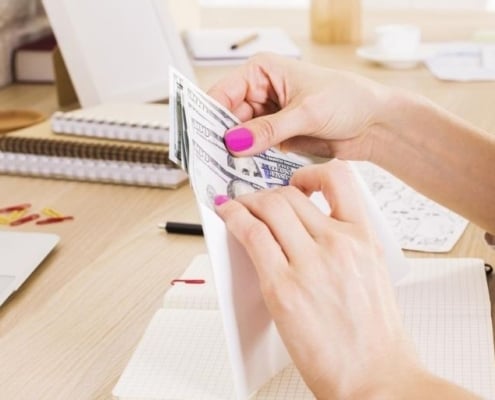 woman's hand stuffing budgeting envelopes free at desk