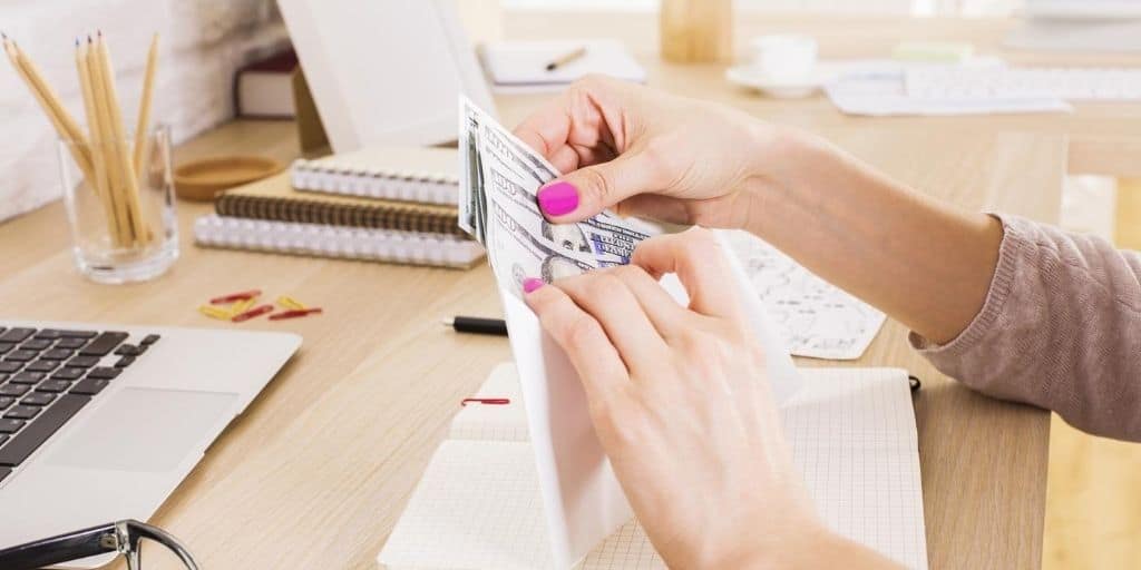 woman's hand stuffing budgeting envelopes free at desk