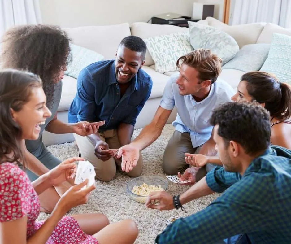 group of adults playing free print and play games for adults PDFs on floor at a party