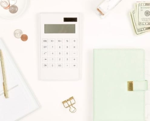 computer flat lay with calculator and notepad showing frugal examples