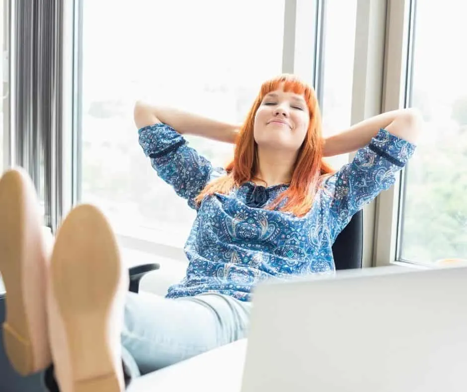 red-headed woman leaning back on desk chair with big smiling, excited about ideas for how to reward yourself for studying