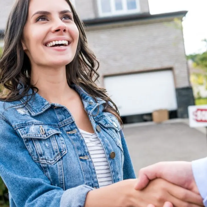 lady shaking hands and smiling with buyer who pick up old appliances for cash