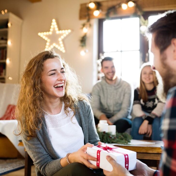 woman smiling accepting gift from boyfriend