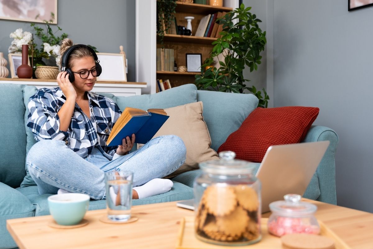 woman with glasses on couch, reading