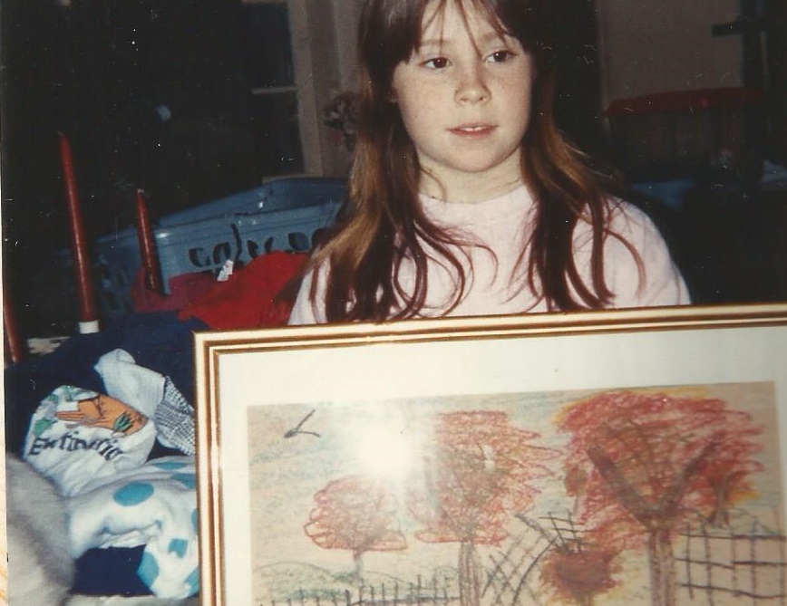 old image of author's sister as a child with her artwork framed, Christmas morning