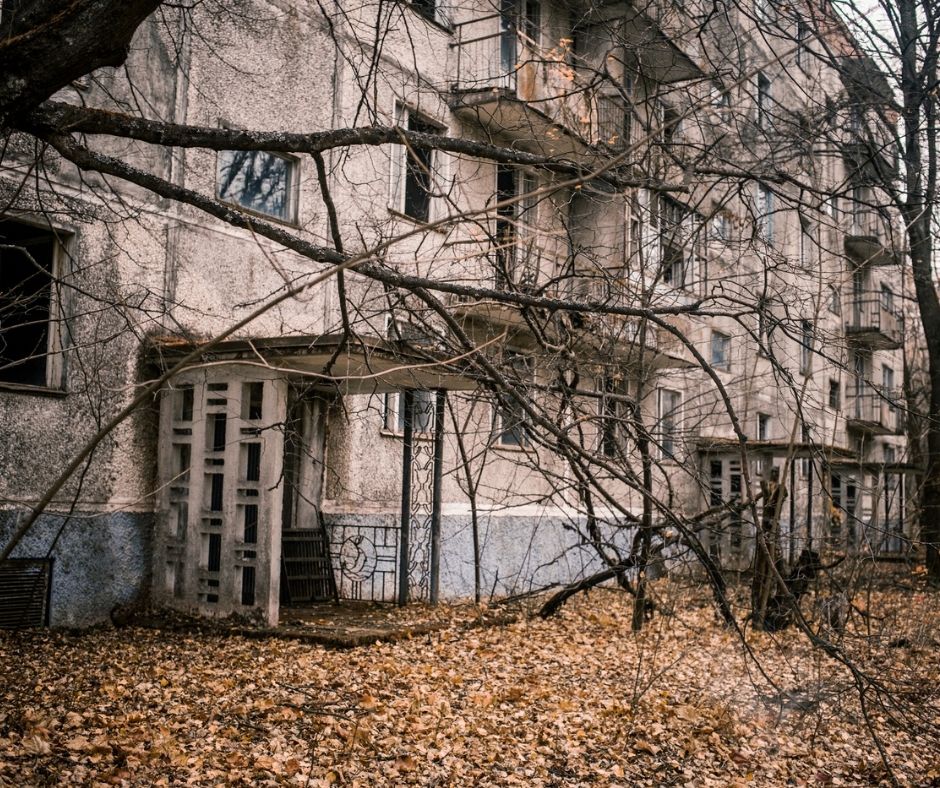 old creepy spooky building with dead trees around it