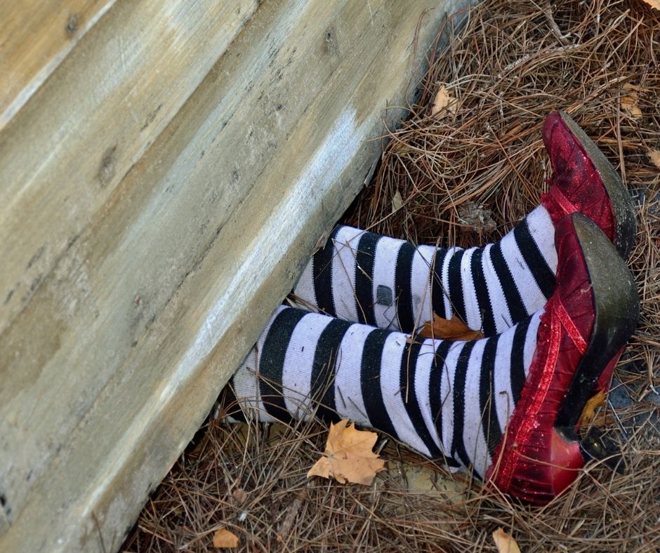 pair of legs with striped stockings and red shoes coming out of building