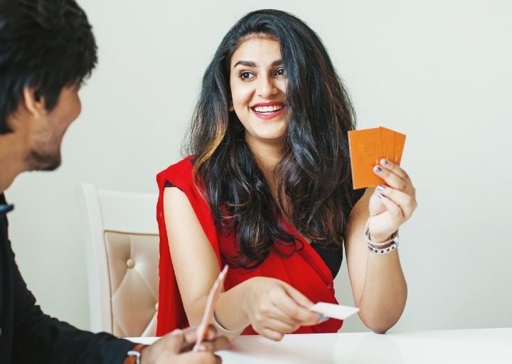 couple smiling at one another, playing with deck of conversation starters for married couples