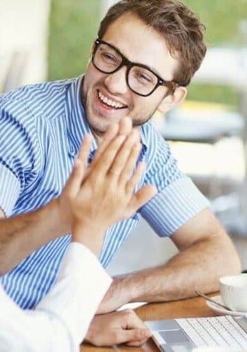 couple smiling and giving a high five while working on couple's financial goals worksheet