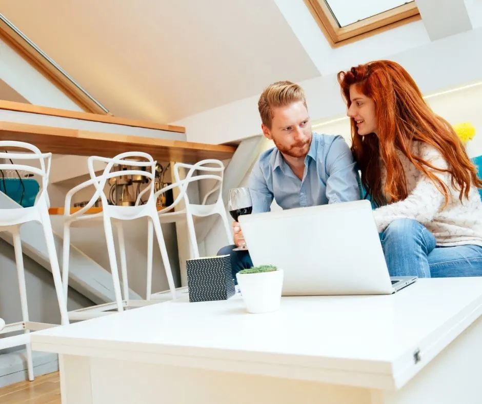 couple sitting down with laptop to do budgeting together