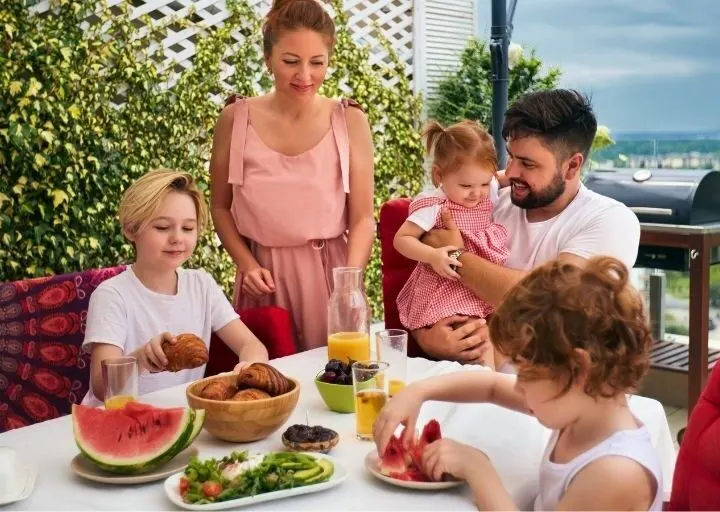 family on vacation eating lunch on a patio