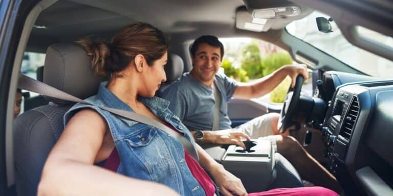 woman and man driving in car, smiling at each other
