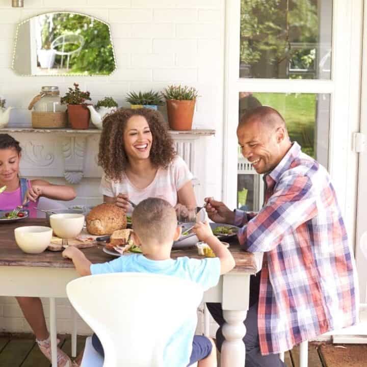 young family eating dinner at home on back patio