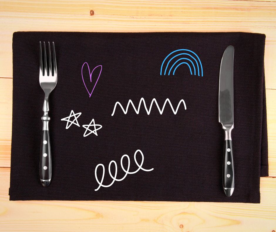 black chalkboard placemat with fork and knife, with doodles on it