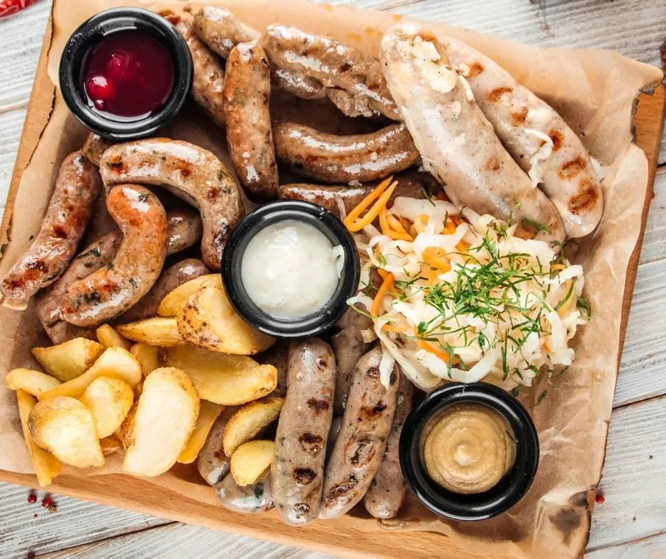 platter of sausages, mustard dips, and potatoes