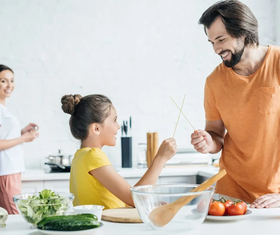 father and daughter in kitchen playing chopsticks karate for family night activity