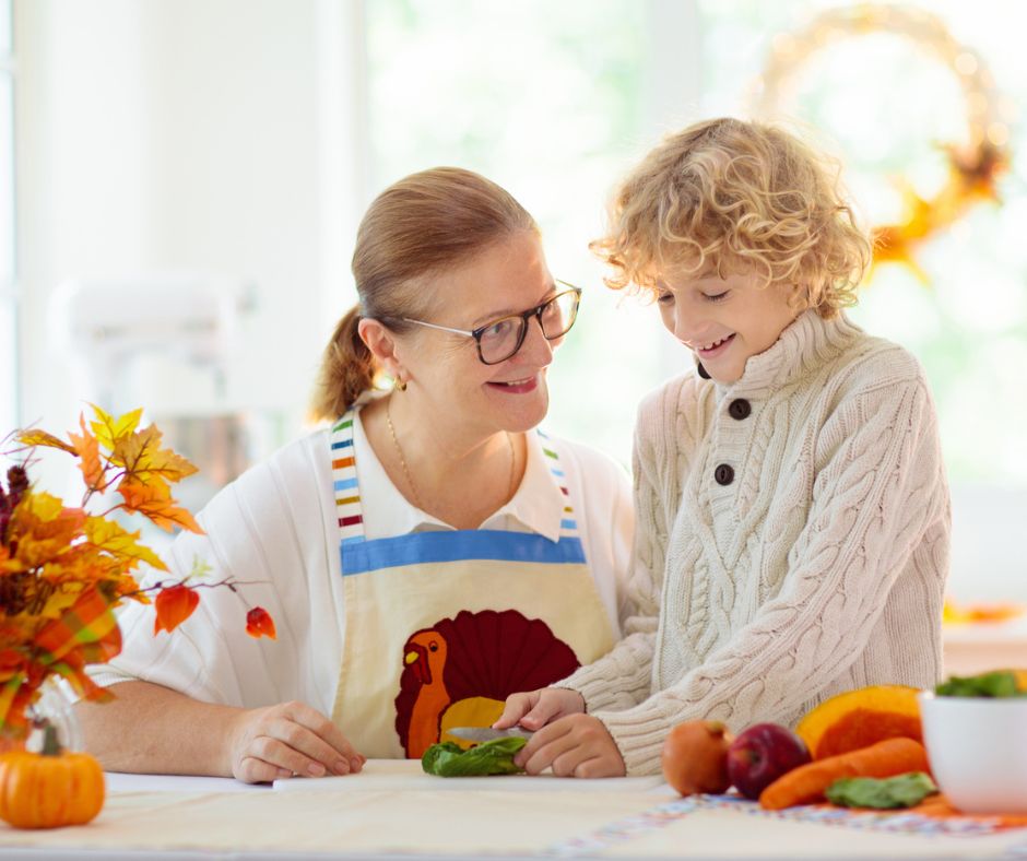 grandmother with turkey on her apron helping grandson making a kid centerpiece for table