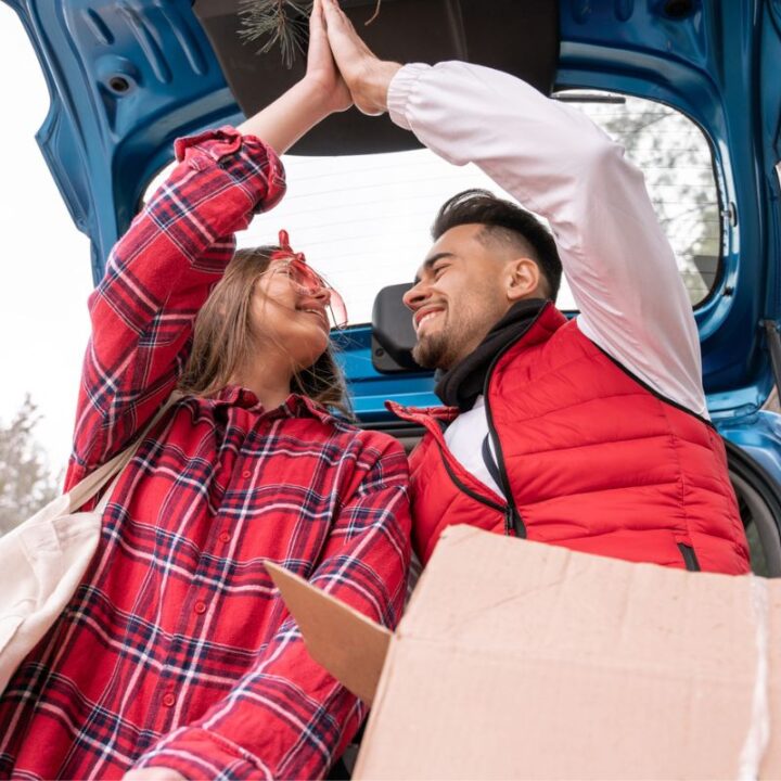 couple giving each other the high five in trunk of car after finishing adult kindness challenge