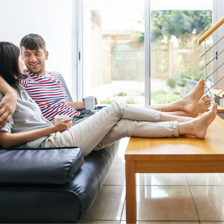 couple with arm around each other on couch, talking and facing each other