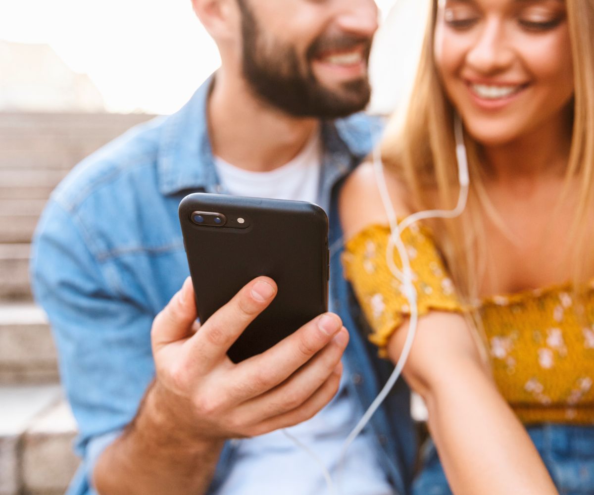 husband and wife listening to crime podcast together, smiling