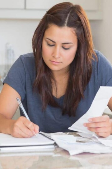 woman in blue shirt working at kitchen counter on family emergency binder