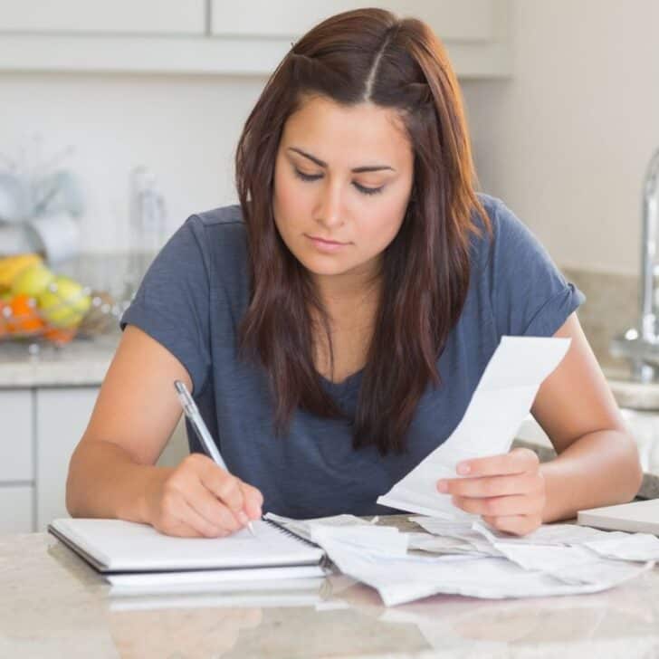 woman in blue shirt working at kitchen counter on family emergency binder