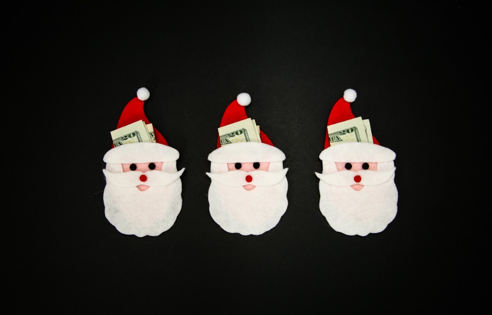three Santas with felt beards holding $20 bills on black background