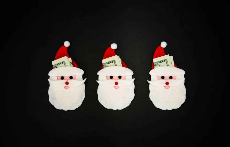 three Santas with felt beards holding $20 bills on black background