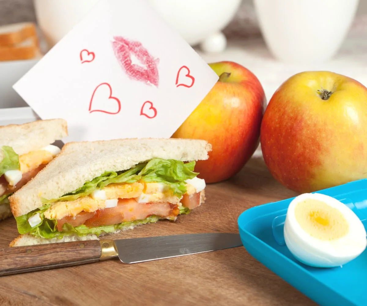 egg salad sandwich on cutting board with love note with kisses on it