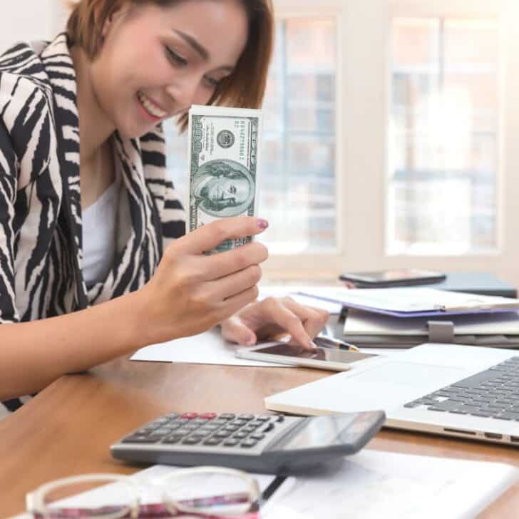 woman in zebra shirt with cash smiling