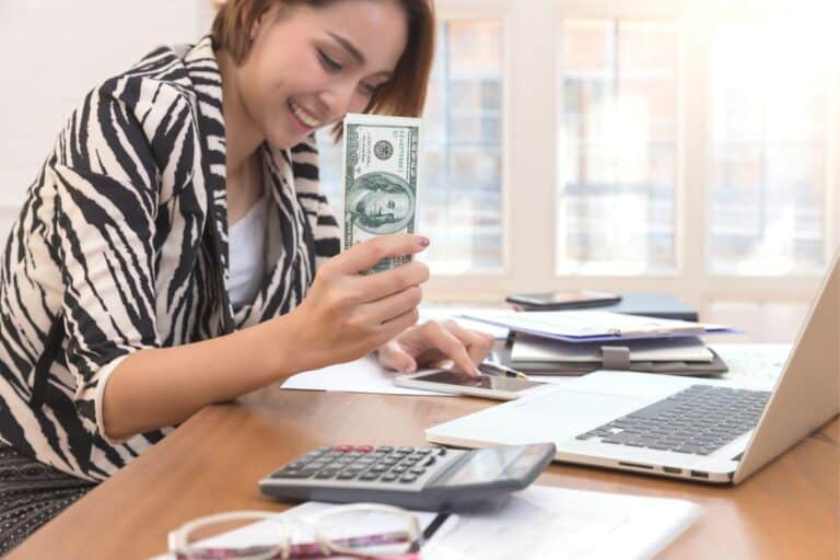 woman in zebra shirt with cash smiling
