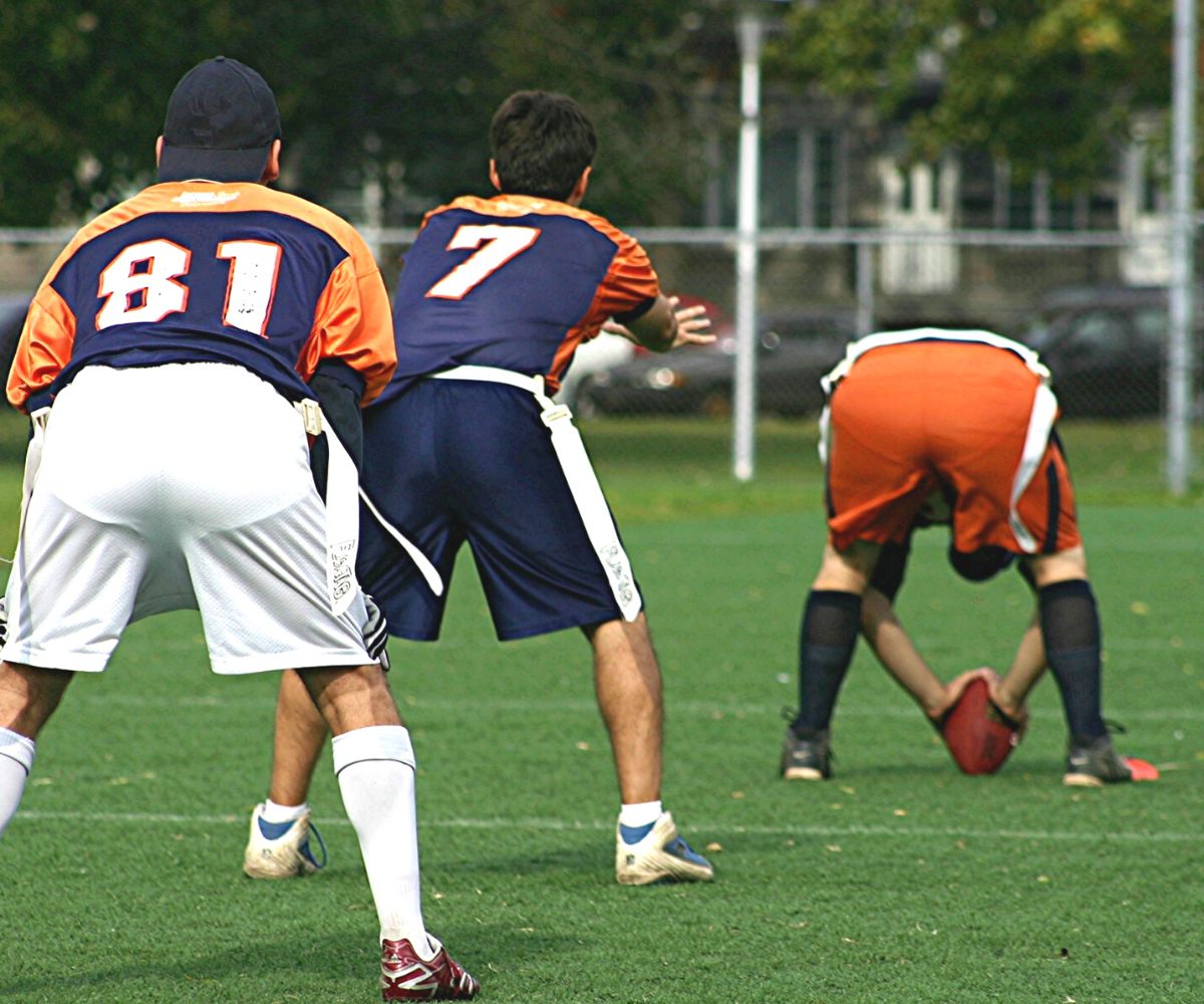group of adult guys playing flag football outdoors