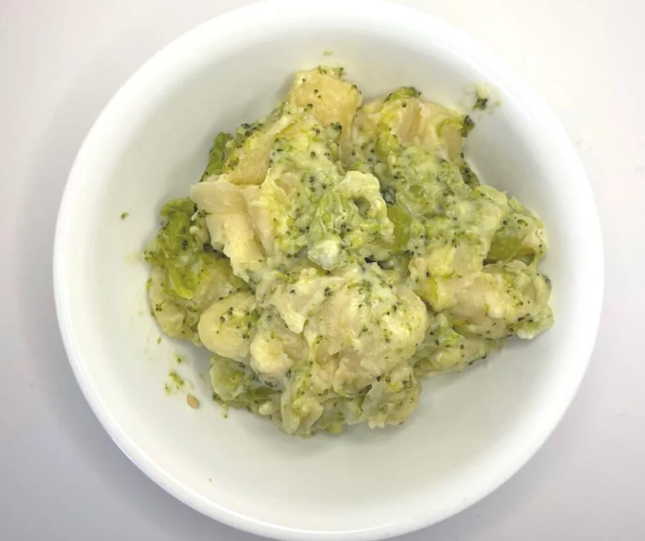 broccoli parmesan gnocci in white bowl on white background